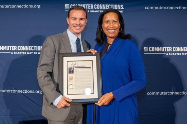 two people smiling holding plaque