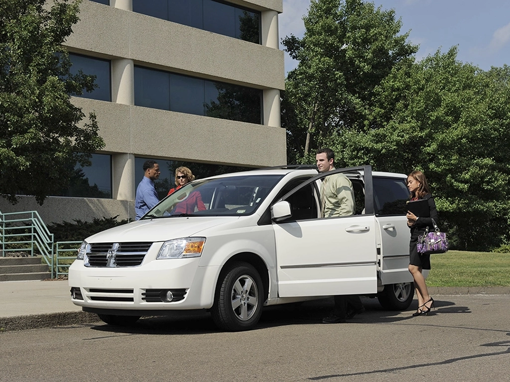 four people getting into a minivan to vanpool